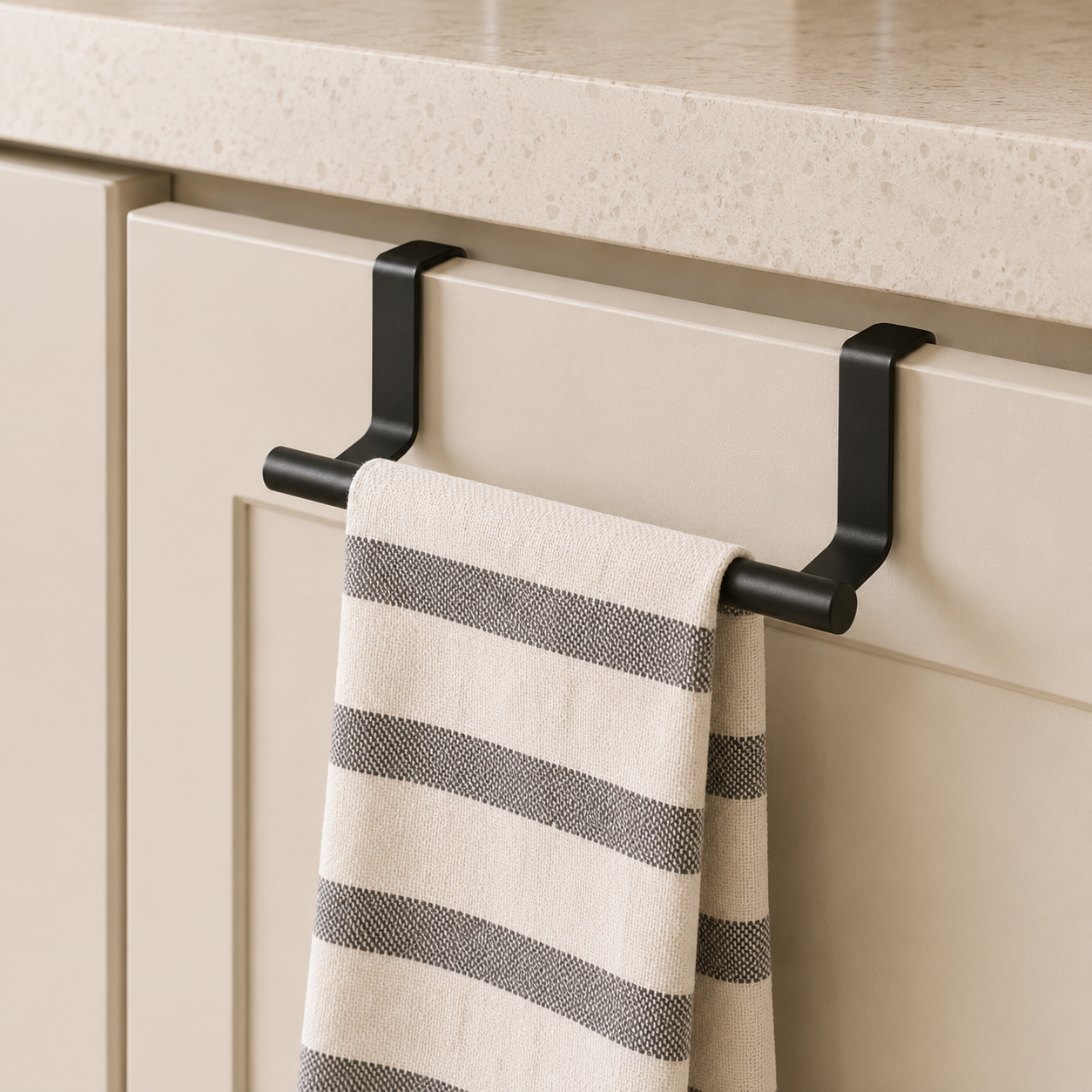 Stainless steel over-cabinet towel rack holding a striped kitchen towel